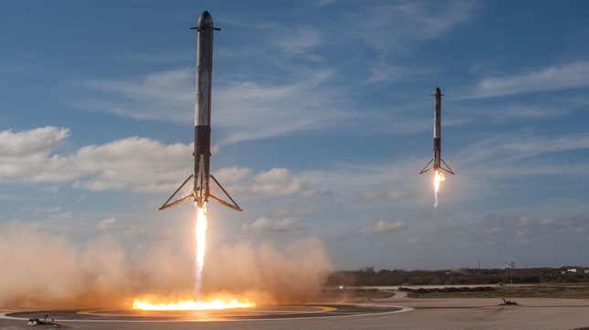 A pair of Falcon Heavy side boosters return for landing during the rocket's first flight in 2018.